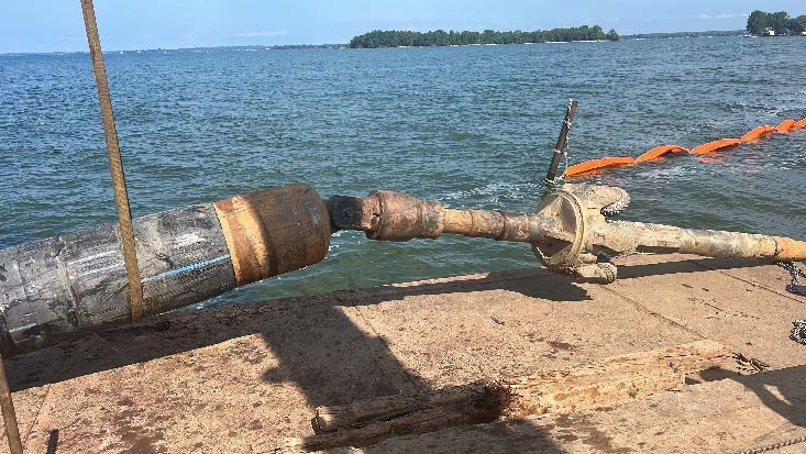 Drilling equipment with a directional drill head positioned at the water's edge, overlooking Lake Ontario, illustrating the installation process for HDPE pipe in Sackets Harbor, NY.