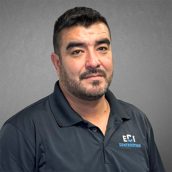 Freddie Padilla, Operations Manager at ECI Contracting, wearing a black polo shirt with the ECI logo, against a gray background, representing expertise in underground construction solutions.